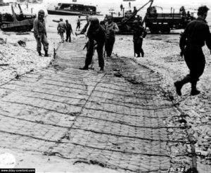 Installation d'un grillage permettant aux véhicules de circuler plus rapidement sur le sable d'Omaha Beach. Photo : US National Archives