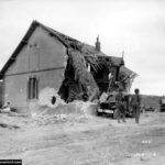 La maison en ruine des Moulins devant Dog Red à l'ouest de la sortie D3. Photo : US National Archives
