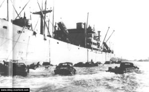 Un Liberty Ship chargeant des véhicules amphibies DUKW au large d'Omaha. Photo : US National Archives