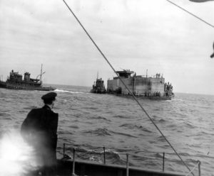 Un caisson Phoenix surmonté d'une tourelle pour canon antiaérien remorqué à travers la Manche. Photo : US National Archives