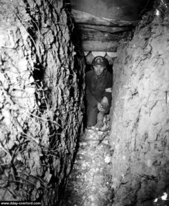 Une tranchée allemande est inspectée par ce sapeur du 5th Engineer Special Brigade à Omaha Beach. Photo : US National Archives