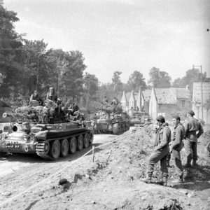 18 juillet 1944 : deux chars Cromwell et un char Sherman Firefly du 1st Royal Tank Regiment, 7th (GB) Armoured Division, rue du Grand Clos à Bénouville pendant l'opération Goodwood. Ils vont traverser la rivière Orne sur le pont Bailey baptisé "London Bridge 1". Photo : George Rodger pour LIFE Magazine