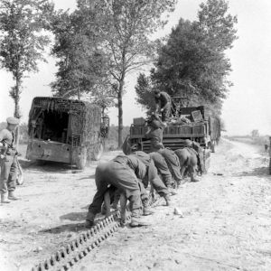 18 juillet 1944 : un char britannique Crusader III AA Mk III le long de la piste bordant le canal de Caen à la mer à Bénouville. Le blindé a déchenillé et une équipe légère d'intervention procède à la réparation avec des pièces de rechange dans son camion Austin K5 3-ton GS. Le Crusader antiaérien appartient au 93rd Light Anti-Aircraft Regiment, Photo : George Rodger pour LIFE Magazine