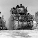 18 juillet 1944 : pendant l'opération Goodwood, un char Sherman Firefly avec tourelle à 6 heures appartenant au 5e peloton (escadron B du 1st Royal Tank Regiment, 22nd Armoured Brigade, 7th GB Armoured Division) quitte Bénouville après avoir traversé le pont Bailey baptisé "London Bridge 1". Photo : George Rodger pour LIFE Magazine