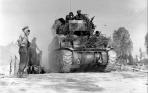 18 juillet 1944 : pendant l'opération Goodwood, un char Sherman Firefly avec tourelle à 6 heures appartenant au 5e peloton (escadron B du 1st Royal Tank Regiment, 22nd Armoured Brigade, 7th GB Armoured Division) quitte Bénouville après avoir traversé le pont Bailey baptisé "London Bridge 1". Photo : George Rodger pour LIFE Magazine