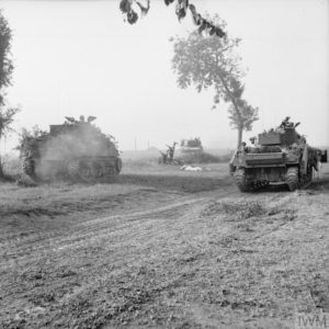 Des chars M4 Sherman et Sherman fléaux appartenant à la 79th (GB) Armoured Division progressent au sud d'Escoville le 18 juillet 1944 pendant l'opération Goodwood. Une vache tuée gît au sol. Photo : IWM B 7549