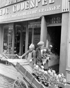 Un civil non-identifié et Blanche Couespel devant son magasin de fleurs au 32 de la rue Saint-Malo à Bayeux durant l'été 1944. Photo : LIFE Magazine