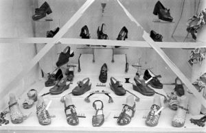 La vitrine d'un marchand de chaussures à Bayeux après la libération durant l'été 1944. L'emploi de bande adhésive sur les vitres limitait la propagation d'éclats en cas de bombardement. Photo : LIFE Magazine