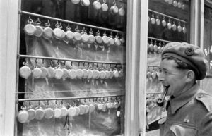 Un sapeur britannique appartenant à la 7th Armoured Divisional Engineers à Bayeux durant l'été 1944 après la libération, devant un magasin vendant des montres à gousset. Photo : DR