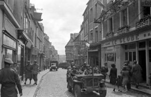 Une Jeep transportant des soldats américains suivie d'un camion Bedford OY dans la rue Saint-Martin à Bayeux durant l'été 1944, après la libération. Photo : DR