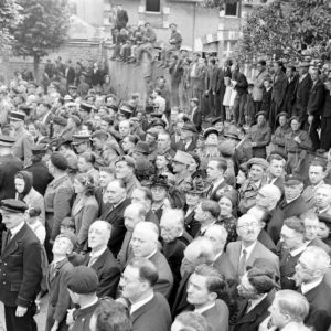 La population normande et des militaires britanniques et français écoutent les discours d'autorités, place aux Pommes le 14 juillet 1944 à Bayeux. Photo : George Rodger pour LIFE Magazine