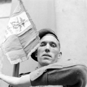 Le second-maître Louis Lanternier, appartenant à la Troop 1 du 1er bataillon de fusiliers marins commandos, porte fanion. Il appartient au piquet d'honneur participant à la cérémonie du 14 juillet 1944 à Bayeux, place aux Pommes. Photo : George Rodger pour LIFE Magazine