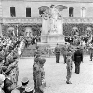 Place aux Pommes à Bayeux le 14 juillet 1944, le colonel de Chevigné remet la Croix de guerre avec palme au gendarme Gouget et la la Croix de guerre à Antoine Mercader, résistant. La cérémonie de décoration est effectuée en présence d'un piquet d'honneur, du 1er bataillon de fusiliers marins commandos aux ordres du lieutenant de vaisseau Alexandre Lofi. Photo : George Rodger pour LIFE Magazine