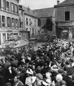 Un convoi de chars Sherman et de Jeep traverse la rue Saint-Laurent à Bayeux le 14 juillet 1944 pendant la cérémonie au monument aux Morts, place aux Pommes. Photo : DR