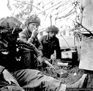 9 juillet 1944 : des soldats du 7th Canadian Infantry Batallion prennent un repas à l’abri de leur véhicule. Photo : IWM