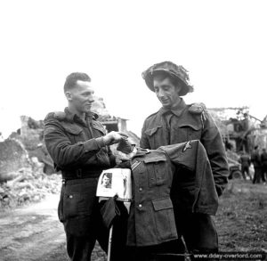 Les soldats Bob Miller et Randall Hillis du 7th Canadian Infantry Battalion réalisent un épouvantail avec un uniforme allemand et un exemplaire de "Mein Kampf" dans le secteur d'Authie. Photo : IWM
