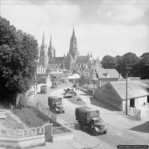 25 juin 1944 : des troupes traversent la ville de Bayeux. La cathédrale Notre-Dame de Bayeux est visible en arrière-plan. Photo : IWM