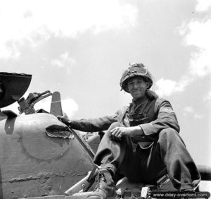 14 juin 1944 : un soldat canadien sur un char M4 Sherman dans Bayeux, un impact direct est visible sur la tourelle. Photo : IWM