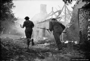 2 août 1944 : des soldats progressent dans les ruines d’une ferme normande dans le secteur de Bény-Bocage. Photo : IWM