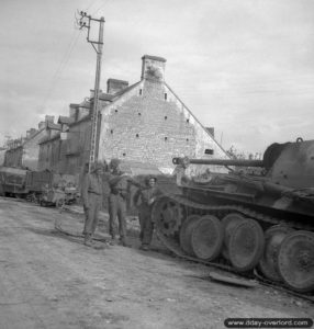 Après les combats, des soldats du Regina Rifles Regiment inspectent l’épave d’un PzKpfw V Panther détruit dans la nuit du 8 au 9 juin 1944 par le tir de Joe Lapointe au P.I.A.T. à Bretteville-l'Orgueuilleuse. Photo : IWM