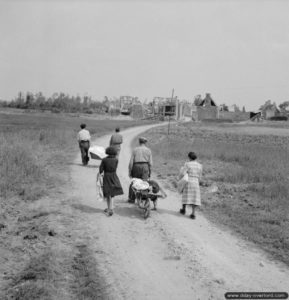 18 juillet 1944 : une famille française habitant Buron retourne dans son village après les combats. Photo : IWM