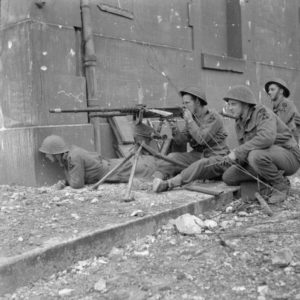 10 juillet 1944 : des soldats du 1 Kings Own Scottish Borderers (KOSB), 9th Brigade, 3rd Infantry Division, utilisant une mitrailleuse Hotchkiss de prise dans les rues de Caen. Photo : IWM