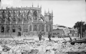 10 juillet 1944 : des troupes britanniques progressent devant les ruines de l’église Saint-Pierre à Caen. Photo : IWM