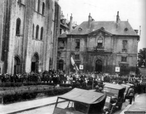 9 juillet 1944 : levée du drapeau français en soirée devant l’abbaye aux Hommes et le lycée Malherbe de Caen. Photo : IWM