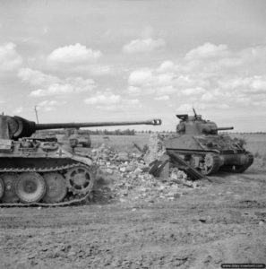26 juin 1944 : pendant l’opération Epsom, une colonne de chars M4 Sherman à proximité d’un char Panther du SS-Pz.Rgt. 12 détruit dans le secteur de Caen. Photo : IWM