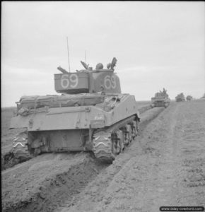 8 juillet 1944 : des chars Sherman appartenant au 144th Regiment Royal Armoured Corps de la 33rd Armoured Brigade dans le secteur de Beuville pendant l’opération Charnwood. Photo : IWM