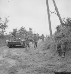 11 juillet 1944 : des soldats et un Universal Carrier de la 59th Division progressent pendant les combats dans le secteur de Caen. Photo : IWM