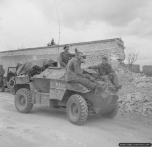 9 juillet 1944 : des prisonniers allemands transportés au-dessus d’un véhicule de de reconnaissance Humber dans le secteur de Caen. Photo : IWM