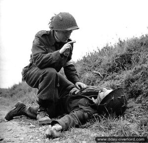 15 juillet 1944 : l’aumônier Robert L. Seaborn, du 1st Battalion, Canadian Scottish Regiment, récite les derniers sacrements pour un soldat de la 3rd Canadian Infantry Division. Photo : IWM