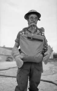 27 juillet 1944 : le Private R. Thorpe, servant à l’Army Fire Service company, fait une démonstration à Caen d’un système de protection contre les gaz dangereux. Photo : IWM