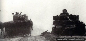 Un char Sherman fléau progresse à proximité d’un Panzer IV carbonisé dans le secteur de Cagny. Photo : IWM