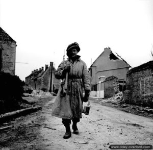 20 juin 1944 : un soldat du Stormont, Dundas, and Glengarry Highlanders traverse les ruines du village du Vieux Cairon. Photo : IWM