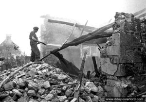 12 juillet 1944 : des sapeurs du Royal Canadian Engineers éteignent des feus causés par des obus allemands. Photo : Archives Canada