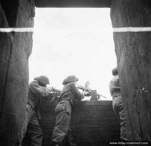 12 juillet 1944 : des soldats canadiens en position avec une mitrailleuse Bren devant une casemate allemande de l’aéroport. Photo : Archives Canada