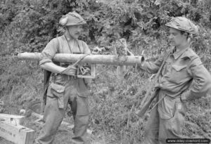 31 juillet 1944 : le sergent F. J. Petrie et le sapeur L. Roberts observent un lance-roquette allemand Panzerschreck récupéré pendant l’offensive sur Caumont-l’Eventé. Photo : US National Archives