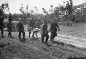 31 juillet 1944 : des blessés sont transportés vers un poste de secours régimentaire pendant l’offensive sur Caumont-l’Eventé. Photo : US National Archives