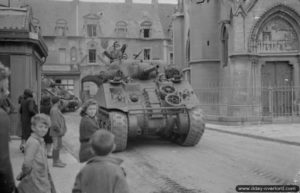 8 juin 1944 : un char Sherman progresse dans Douvres-la-Délivrande. Photo : IWM