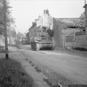 18 juillet 1944 : des chars Sherman et Firefly progressent dans Escoville lors de l’opération Goodwood. Photo : IWM