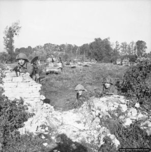 18 juillet 1944 : de l’infanterie et des blindés attendent l’ordre de franchir la ligne de débouché lors de l’opération Goodwood. Photo : IWM