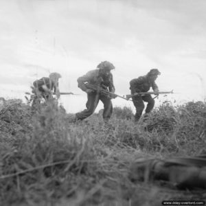 29 juin 1944 : des soldats anglais de la 8th Rifle Brigade (Motor) de la 11th Armoured Divsion progressent lentement à proximité d’Eterville. Photo : IWM