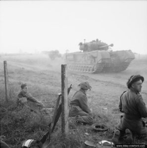 16 juillet 1944 : des soldats du Royal Welch Fusiliers observent un char Churchill pendant l’attaque de la commune d’Evrecy. Photo : IWM