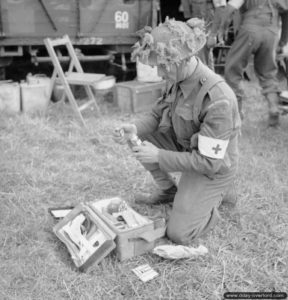 16 juillet 1944 : le sergent G. S. Davies du Royal Welch Fusiliers prépare sa valise médicale en préparation de l’attaque de la commune d’Evrecy. Photo : IWM
