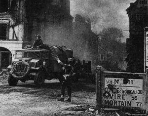 Un soldat de la police militaire britannique dirige le trafic dans les ruines de Falaise. Photo : IWM