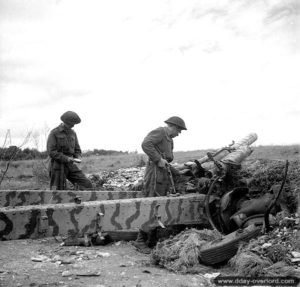 2 juillet 1944 : les soldats canadiens H. H. deVries et M. A. Sallows inspectent un obusier allemand 122 mm abandonné dans le secteur de Fontaine-Henry. Photo : Archives Canada