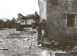 Un Grenadier et un char Panther G camouflé derrière les bâtiments au centre du village de Fontenay-le-Pesnel. Photo : Bundesarchiv