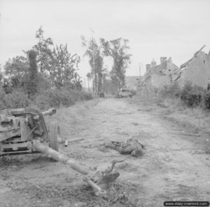 25 juin 1944 : un canon antichar Pak 40 de 75 mm et un de ses servants tués à proximité. Au loin, un char Panther et un char Sherman détruits. Photo : IWM